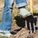 personne retournant le sol avec une grelinette