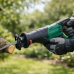 Gros plan sur une scie sabre Parkside verte et noire coupant une branche d'arbre. Outil idéal pour vos projets de jardinage.